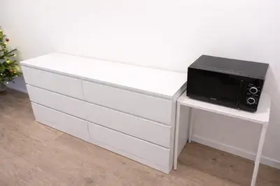 a white dresser with a microwave on top of it at Modern apartment in the Amadeus residence in Prague
