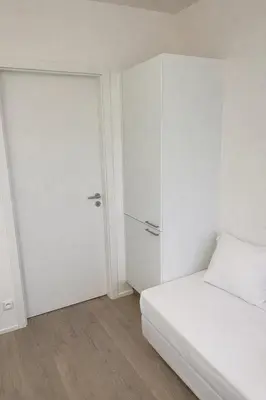 a white bedroom with a bed and a closet at Modern apartment in the Amadeus residence in Prague