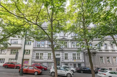 a large white building with cars parked in a parking lot at Entire unit next to Wenceslas Square in Prague