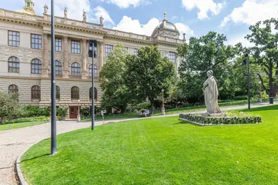a statue in the grass in front of a building at Entire unit next to Wenceslas Square in Prague