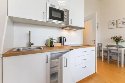 a kitchen with white cabinets and a sink and a microwave at Entire unit next to Wenceslas Square in Prague