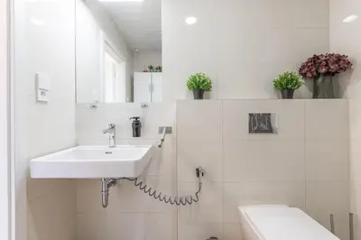 a white bathroom with a sink and a toilet at Entire unit next to Wenceslas Square in Prague
