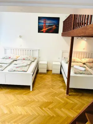 two beds in a room with wooden floors at Apartment v centrum Praha in Prague