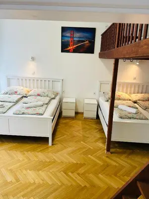 two beds in a room with wooden floors at Apartment v centrum Praha in Prague