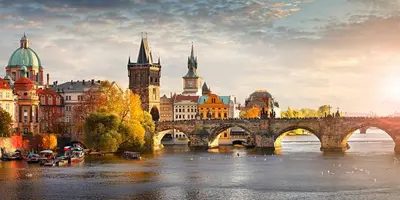 a bridge over a river in front of a city at Apartment v centrum Praha in Prague