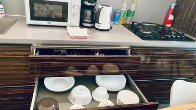 a cabinet with plates and a microwave on a counter at Luxus room in Prague 2 Square in Prague