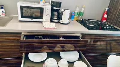 a kitchen with a counter with a microwave and plates at Luxus room in Prague 2 Square in Prague