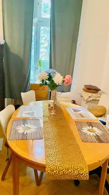 a wooden table with a vase of flowers on it at Luxus room in Prague 2 Square in Prague