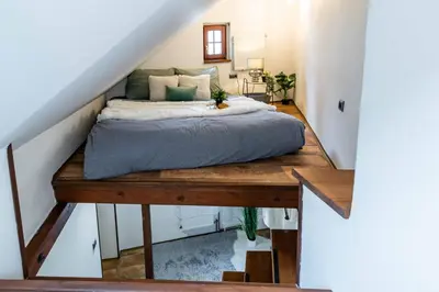 a bed sitting on a wooden table in a room at Apartmán U Hluboké studny in Rakovník