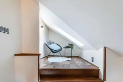 a stairway with a blue chair sitting on a wooden floor at Apartmán U Hluboké studny in Rakovník