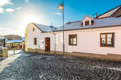 a white house with a cobblestone street at Apartmán U Hluboké studny in Rakovník