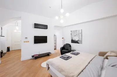 a white bedroom with a bed and a couch at LUXURY Apartman 2 min CHARLES BRIDGE in Prague
