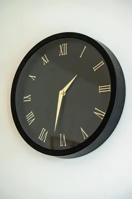 a black clock with gold roman numerals on a wall at Luxury Urban Suite in Prague