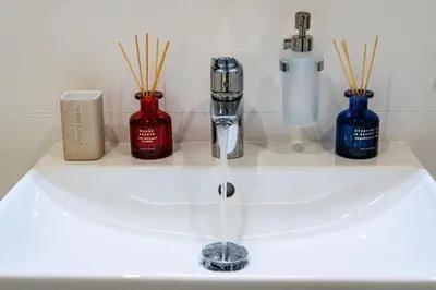 a bathroom sink with a faucet and three bottles at Luxury Urban Suite in Prague