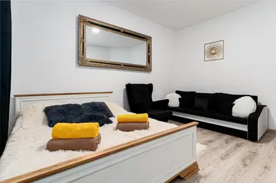 a bedroom with a bed with a mirror and a couch at Crown of Leo in Prague