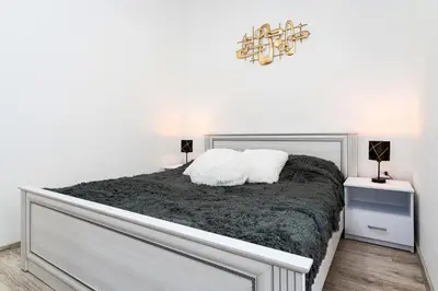 a white bedroom with a large bed with two pillows at Crown of Leo in Prague