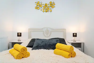 a bedroom with a large bed with yellow pillows at Crown of Leo in Prague