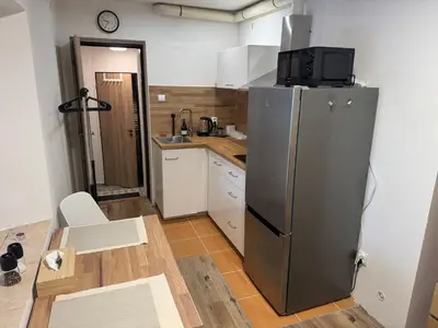 a kitchen with a stainless steel refrigerator and a table at Apartmán na Hejtmánce u letiště v Mladé Boleslavi in Mladá Boleslav