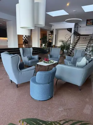 a lobby with blue chairs and a table and stairs at Apartmán VBloku in Prague
