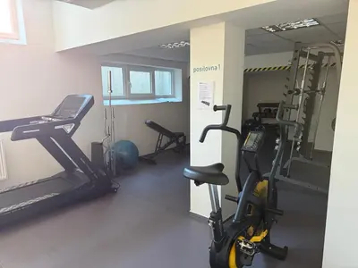 a gym with two treadmills and two exercise bikes at Apartmán VBloku in Prague