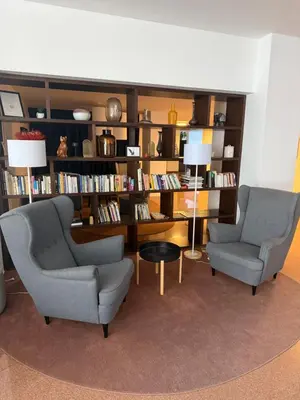 a living room with two chairs and a book shelf at Apartmán VBloku in Prague