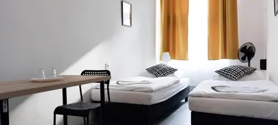 a room with two beds and a table and a desk at Boutique Hotel Milady H in Prague