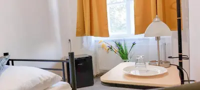 a bedroom with a table with a lamp and a bed at Boutique Hotel Milady H in Prague