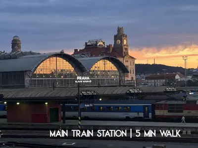 a train station with a clock tower and a train at Charming home near Old Town and Central Station in Prague