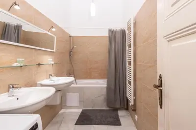a bathroom with two sinks and a tub and a toilet at Charming home near Old Town and Central Station in Prague
