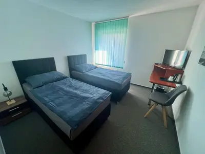 a bedroom with two beds and a desk and a chair at Hotel CAVOK letiště Příbram in Drásov