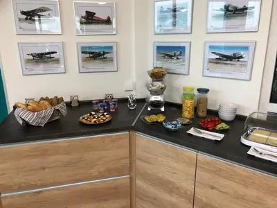 a counter with food and pictures on the wall at Hotel CAVOK letiště Příbram in Drásov