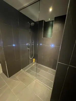 a bathroom with a shower with a glass door at Duplex Design Flat 3 Bäder Garten 160 m2 in Prague