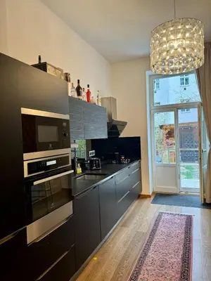 a kitchen with black appliances and a large window at Duplex Design Flat 3 Bäder Garten 160 m2 in Prague