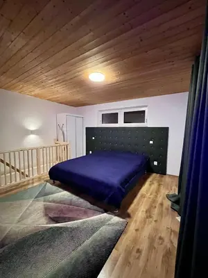 a bedroom with a purple bed and a wooden ceiling at ZANIK Cozy Haven in Prague