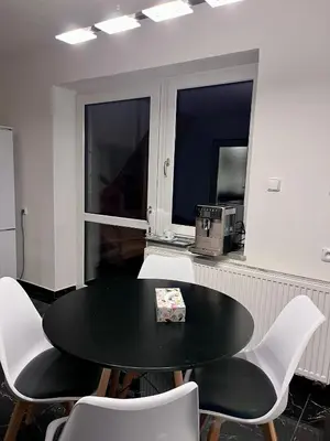 a black table and chairs in a room with windows at ZANIK Cozy Haven in Prague