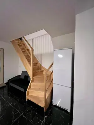 a wooden staircase in a room with a refrigerator at ZANIK Cozy Haven in Prague