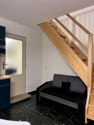 a living room with a black couch and stairs at ZANIK Cozy Haven in Prague