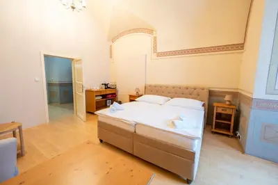 a bedroom with a large bed with white sheets at Zámek v Kostelci nad Černými lesy in Kostelec nad Černými Lesy