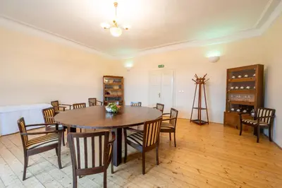 a dining room with a wooden table and chairs at Zámek v Kostelci nad Černými lesy in Kostelec nad Černými Lesy