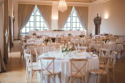 a room full of tables and chairs with white linens at Zámek v Kostelci nad Černými lesy in Kostelec nad Černými Lesy