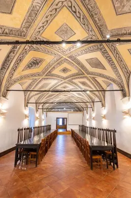 a large room with a row of tables and chairs at Zámek v Kostelci nad Černými lesy in Kostelec nad Černými Lesy