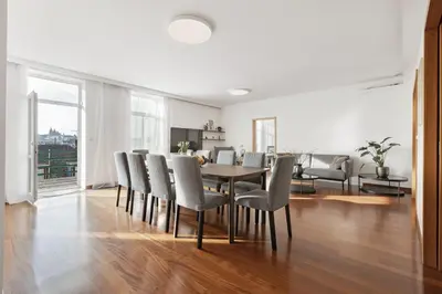 a dining room and living room with a table and chairs at Skyline 127m Residence with Terrace - Prague Castle View in Prague