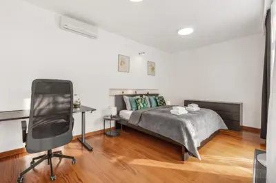 a bedroom with a bed and a desk and a chair at Skyline 127m Residence with Terrace - Prague Castle View in Prague