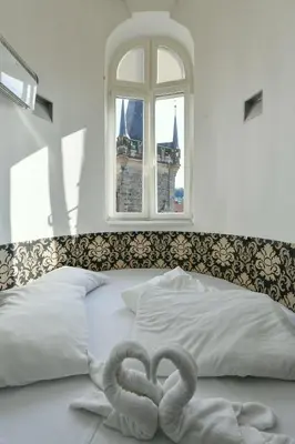 two swan towels on a bed with a window at Amazing Charles Bridge Apartment in Prague