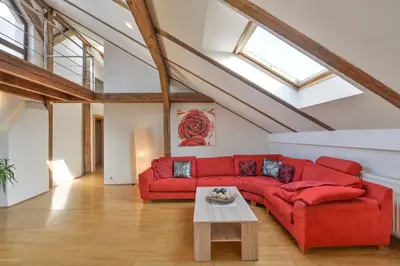 a living room with a red couch and a table at Amazing Charles Bridge Apartment in Prague