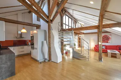 a kitchen and a living room with a staircase in a loft at Amazing Charles Bridge Apartment in Prague
