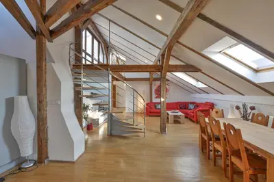 a loft with a staircase and a red couch at Amazing Charles Bridge Apartment in Prague
