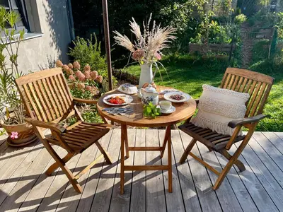 a table and two chairs on a patio at Honey Gardens venkovský apartmán v přírodní zahradě in Oleška