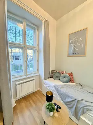 a bedroom with a bed and a table and a window at Cozy museum view studio 104 in Prague