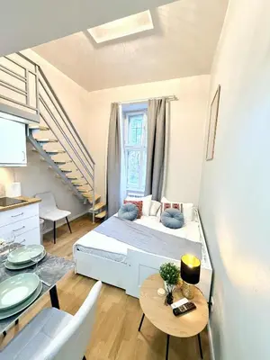 a small bedroom with a bed and a table at Cozy museum view studio 104 in Prague
